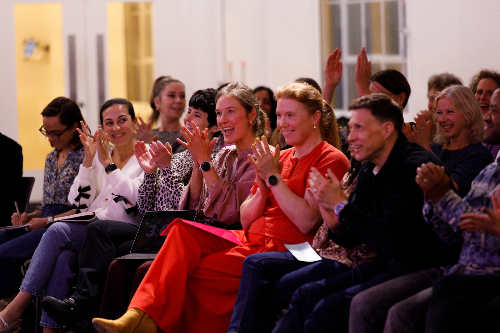 Audience laughing and applauding at one of Cara's talks